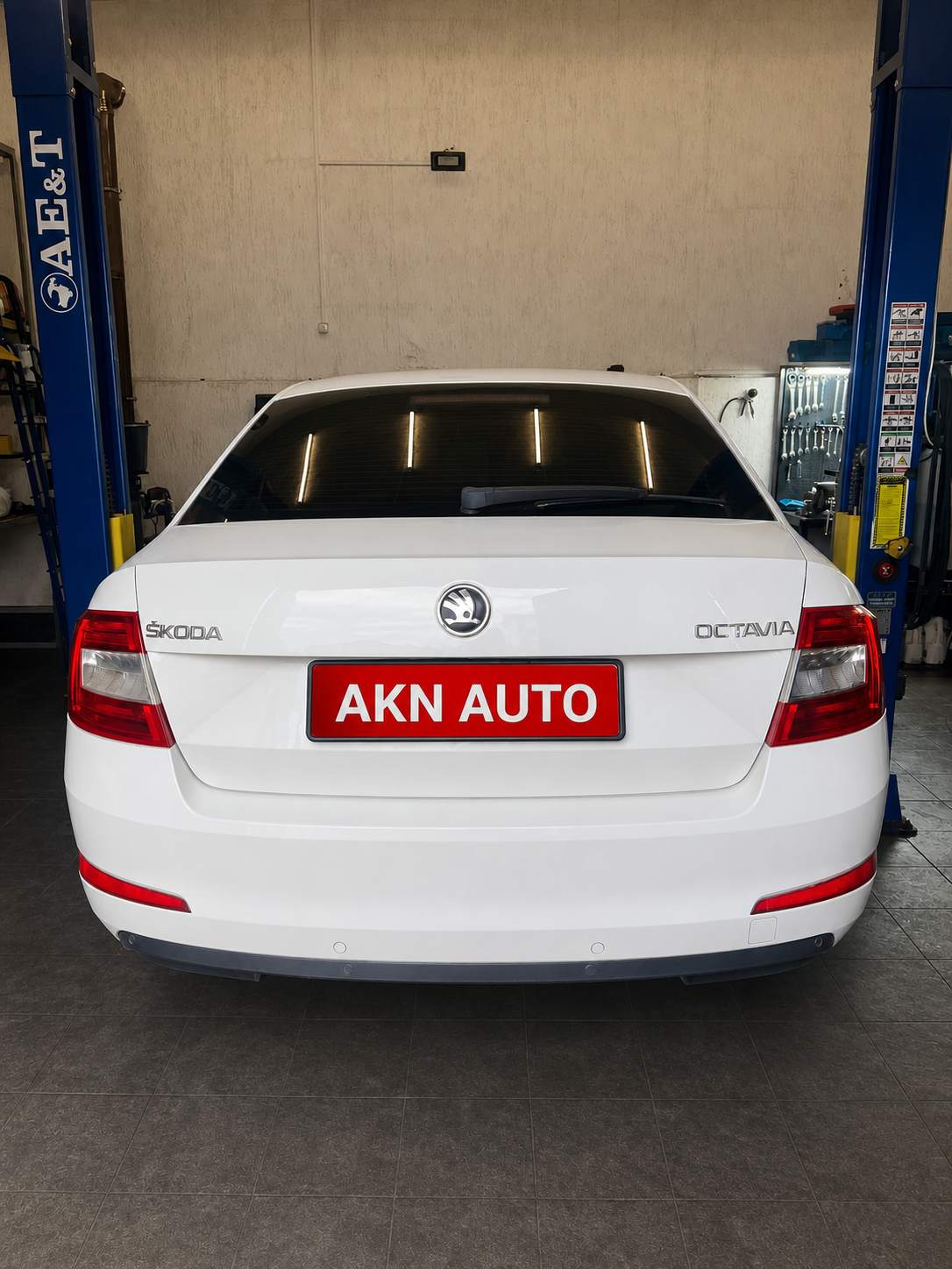 Skoda Octavia 2013, вид сзади между стойками подъёмника в мастерской AKN Auto — akn-avto.ru.